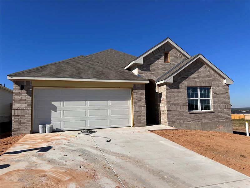 Ranch-style home featuring driveway, brick siding, an attached garage, and a shingled roof Ranch-style home featuring driveway, brick siding, an attached garage, and a shingled roof