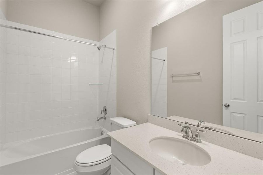 The secondary bath features tile flooring, white cabinetry and light countertops and a shower/tub combo. Perfect for accommodating any visiting family and friends.