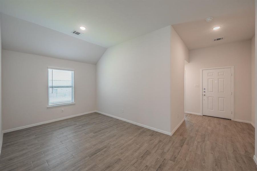 Additional living space with light wood finished floors, recessed lighting, and vaulted ceiling Additional living space with light wood finished floors, recessed lighting, and vaulted ceiling