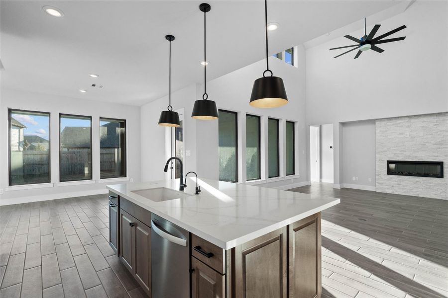 Enjoy commanding sightlines across the oversized kitchen island into the family room, where the gorgeous fireplace creates an immediate focal point in this open-concept layout.