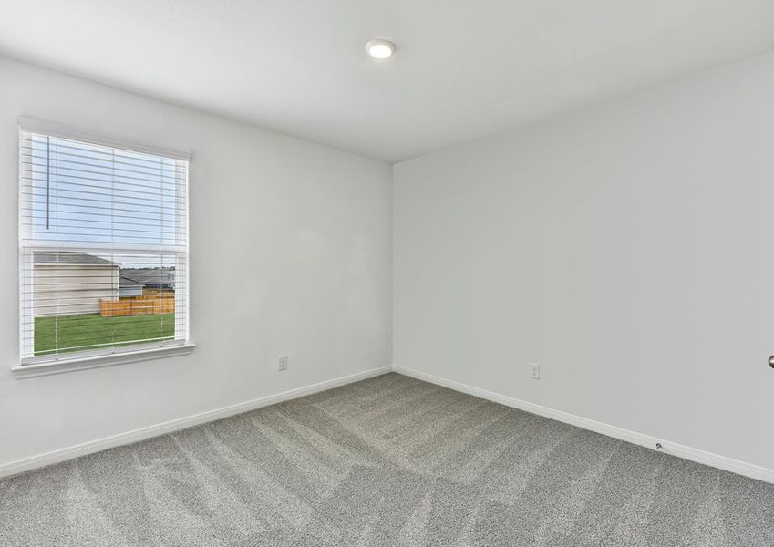 Carpeted secondary bedroom featuring a window with natural light.