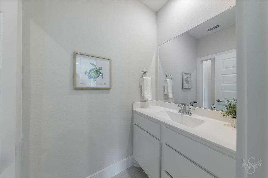 Contemporary secondary bath features a sleek vanity, expansive mirror and crisp finishes that continue the home’s modern design. Contemporary secondary bath features a sleek vanity, expansive mirror and crisp finishes that continue the home’s modern design.