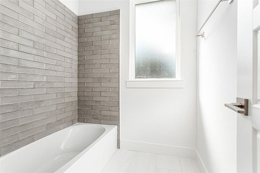 Bathroom with shower / tub combination and light tile patterned floors