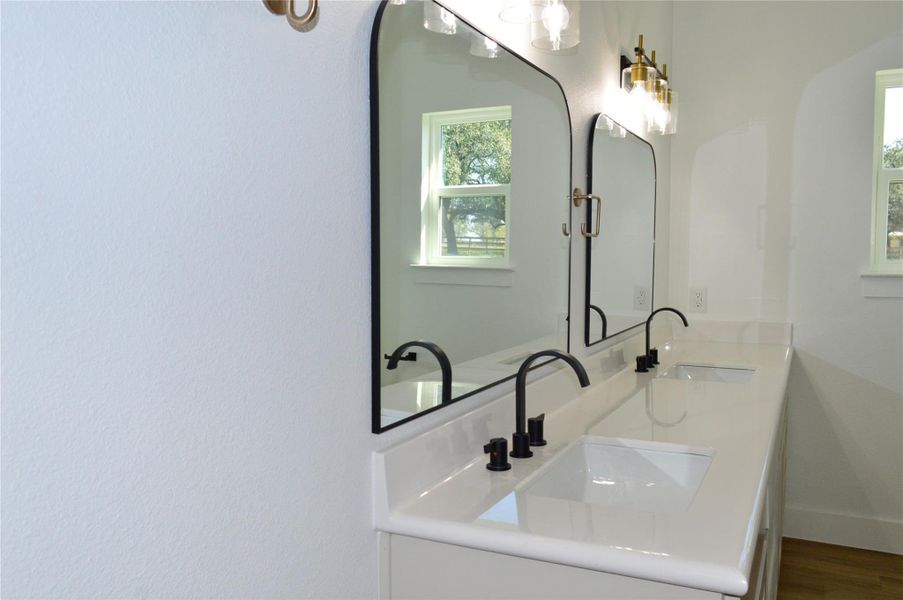 Full bathroom featuring double vanity and wood finished floors Full bathroom featuring double vanity and wood finished floors