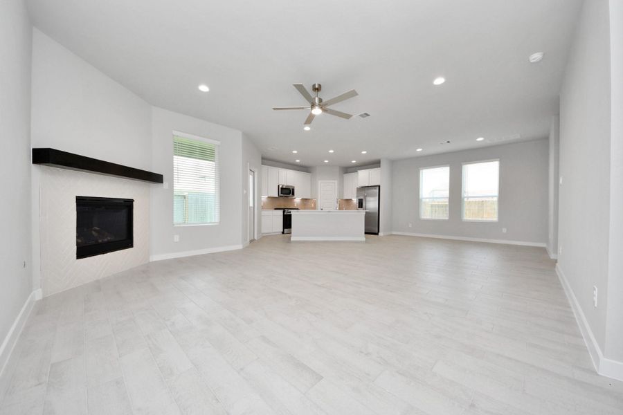 Welcome family and guests to your charming living room! With its high ceilings, recessed lighting, ceiling fan, custom paint, beautiful flooring, and large windows that let in abundant natural light, this room is perfect for gatherings. Sample photo of completed home with similar floor plan. Actual colors and selections may vary. Welcome family and guests to your charming living room! With its high ceilings, recessed lighting, ceiling fan, custom paint, beautiful flooring, and large windows that let in abundant natural light, this room is perfect for gatherings. Sample photo of completed home with similar floor plan. Actual colors and selections may vary.