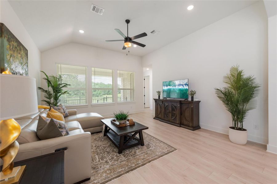 Natural light floods this living room, featuring soaring vaulted ceilings and light wood-tone flooring. Natural light floods this living room, featuring soaring vaulted ceilings and light wood-tone flooring.