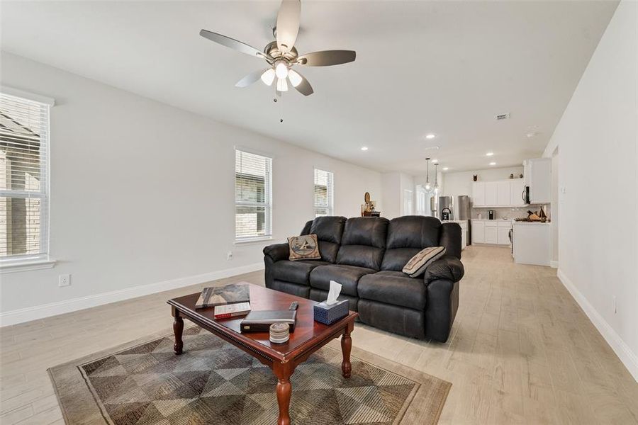 Living area with light wood-type flooring, recessed lighting, and ceiling fan Living area with light wood-type flooring, recessed lighting, and ceiling fan