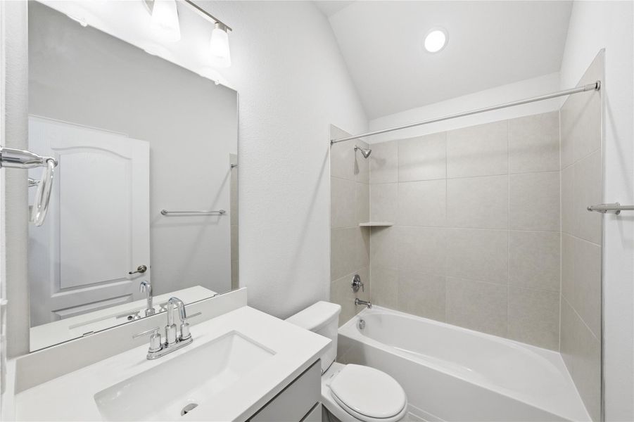 Full bath featuring washtub / shower combination, vanity, lofted ceiling, and recessed lighting Full bath featuring washtub / shower combination, vanity, lofted ceiling, and recessed lighting