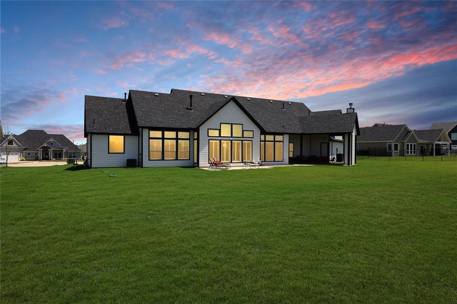 Rear view of house with a lawn and roof with shingles Rear view of house with a lawn and roof with shingles