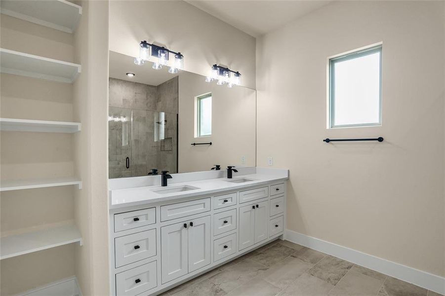 Bathroom featuring double vanity and a stall shower Bathroom featuring double vanity and a stall shower