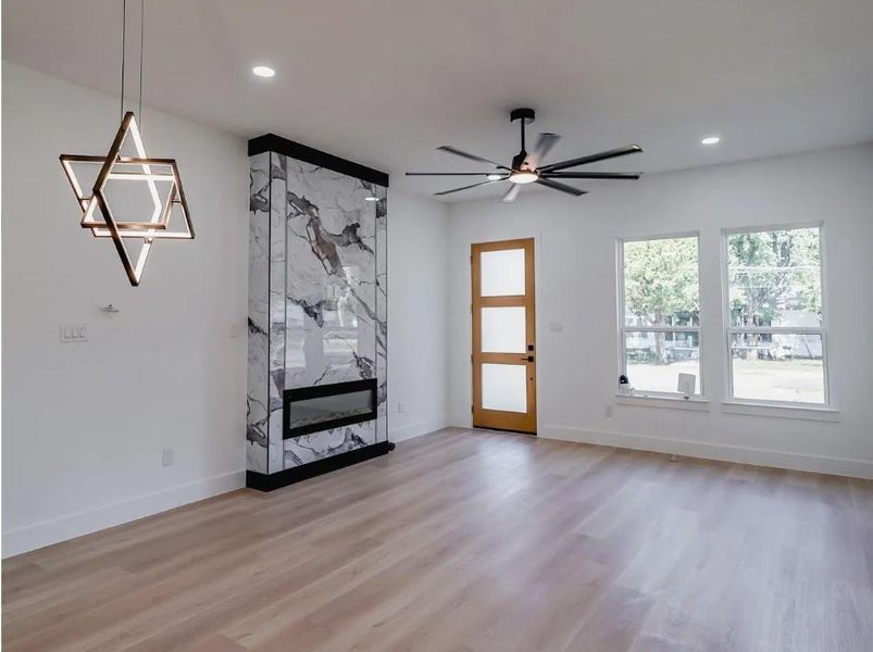 Unfurnished living room with a fireplace, light wood-style floors, ceiling fan, and recessed lighting