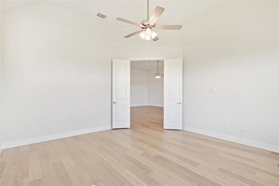 Spare room with ceiling fan, high vaulted ceiling, and light hardwood / wood-style flooring