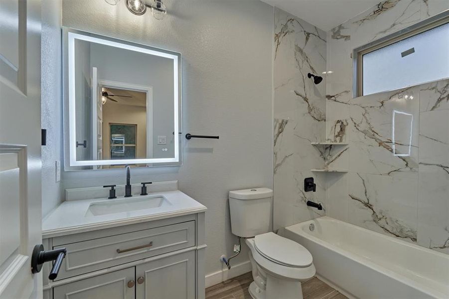 Ensuite bath with tub and shower and LED vanity mirror.