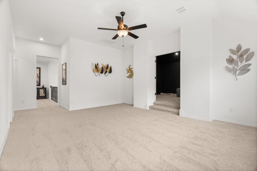 A versatile bonus room features a cooling ceiling fan and plush neutral carpeting throughout. A versatile bonus room features a cooling ceiling fan and plush neutral carpeting throughout.