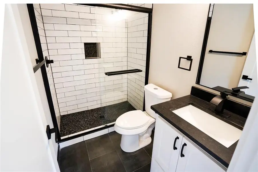 Bathroom featuring a stall shower, vanity, and tile patterned floors