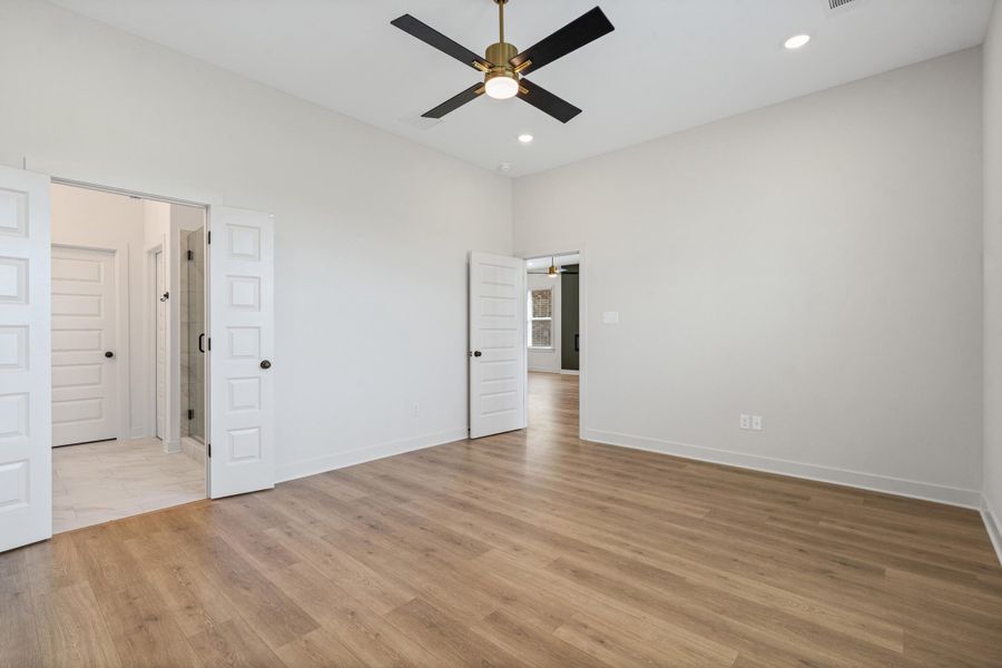 Unfurnished bedroom with ceiling fan, recessed lighting, light wood-style flooring, and a high ceiling
