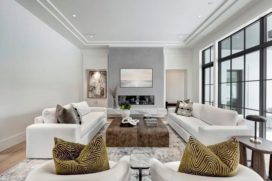 Vibrant living room is anchored by a linear gas fireplace showcased in a Segreto plaster accent wall