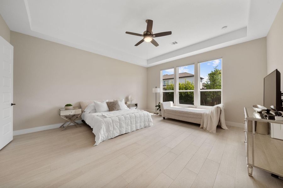 This spacious primary bedroom is designed for comfort and relaxation, featuring large windows that fill the room with natural light. With a neutral color palette and a modern ceiling fan, the room offers a serene atmosphere. This spacious primary bedroom is designed for comfort and relaxation, featuring large windows that fill the room with natural light. With a neutral color palette and a modern ceiling fan, the room offers a serene atmosphere.