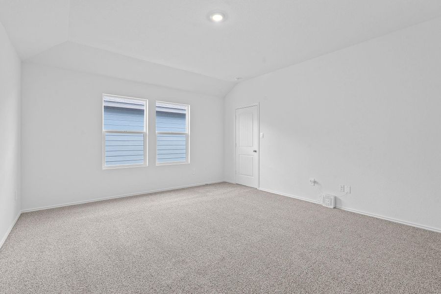 Spare room featuring lofted ceiling and carpet Spare room featuring lofted ceiling and carpet