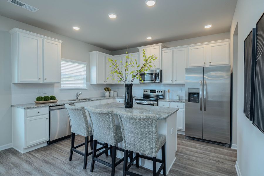 Kitchen showcases a unique center island and plenty of cabinet space