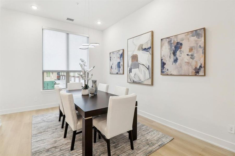 Dining area with recessed lighting, light wood-type flooring, visible vents, and baseboards