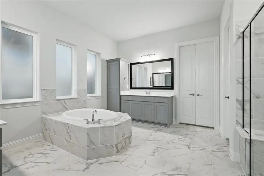 Bathroom featuring marble look tile flooring, a bath, vanity, and a shower stall