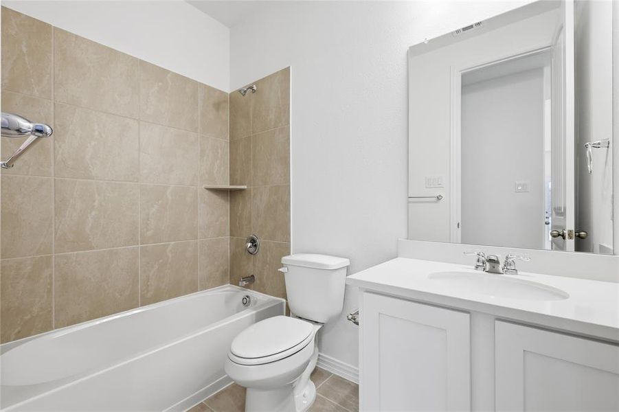Bathroom with shower / bath combination, vanity, and light tile patterned flooring