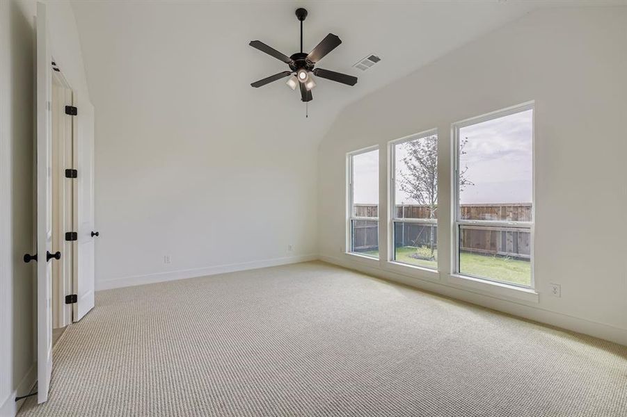 Unfurnished room with light carpet, ceiling fan, and high vaulted ceiling Unfurnished room with light carpet, ceiling fan, and high vaulted ceiling
