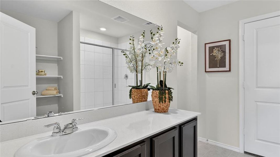 Bathroom vanity featuring a single oval sink, chrome-finish faucet, and a light-toned countertop Bathroom vanity featuring a single oval sink, chrome-finish faucet, and a light-toned countertop