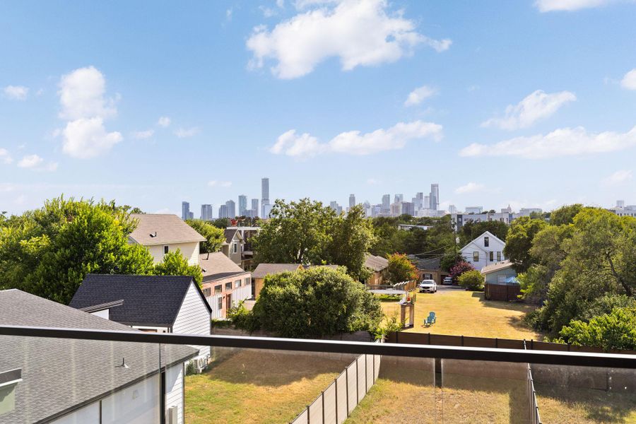 A captivating city view from a raised balcony, featuring an urban skyline against a clear sky.