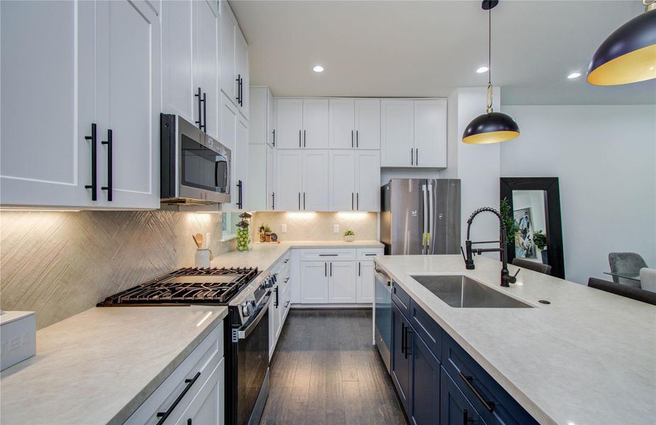 Contrasting blue island cabinets. Stainless steel appliances included