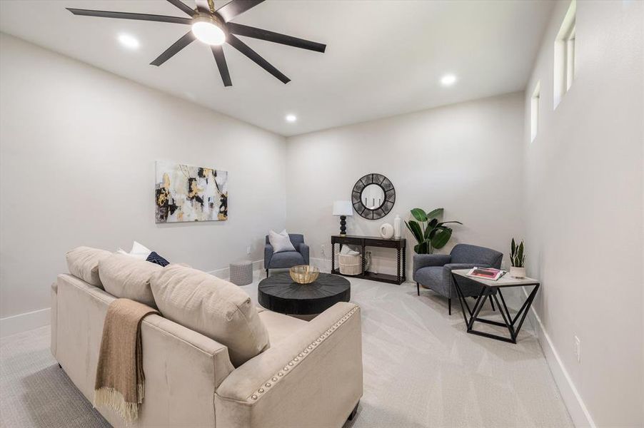 Living room with ceiling fan and light carpet