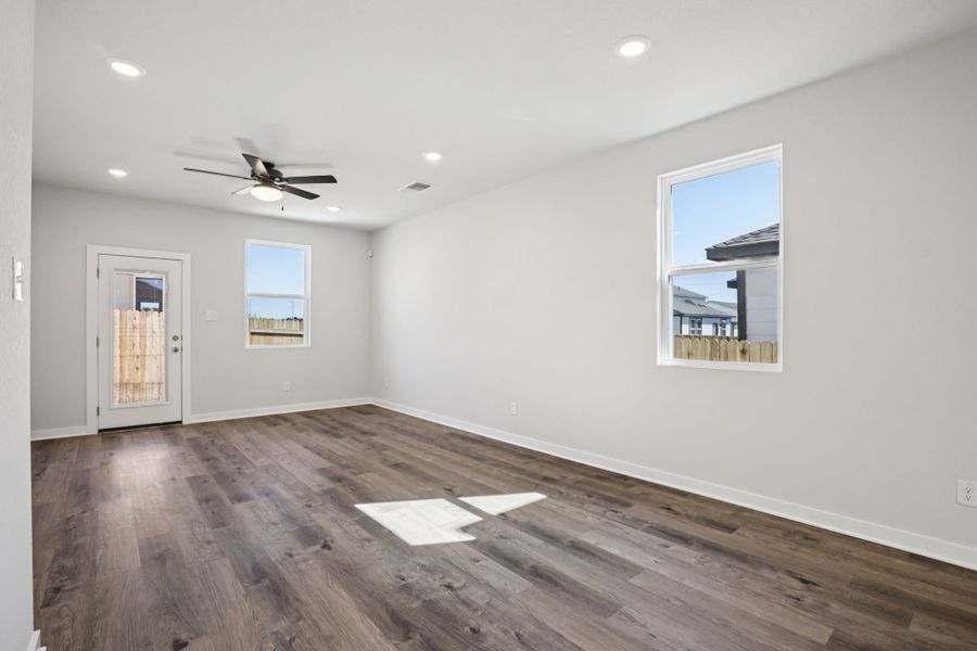 A room with a wood floor and a ceiling fan. A room with a wood floor and a ceiling fan.