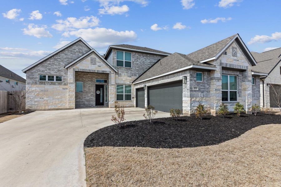 View of front of house featuring a shingled roof, concrete driveway, fence, and an attached garage