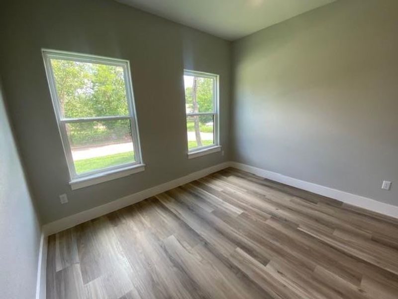 Two large windows illuminate this serene room, featuring durable wood-look flooring. Two large windows illuminate this serene room, featuring durable wood-look flooring.