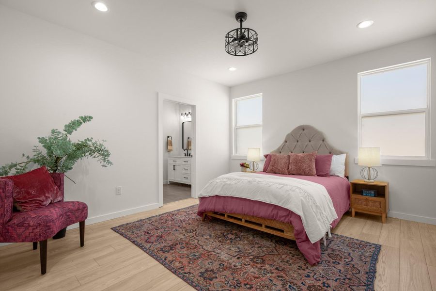 Bedroom with ensuite bathroom, light wood finished floors, and recessed lighting
