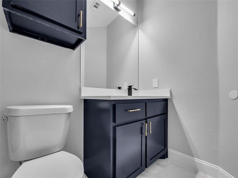 Bathroom featuring a vanity and light marble finish flooring Bathroom featuring a vanity and light marble finish flooring