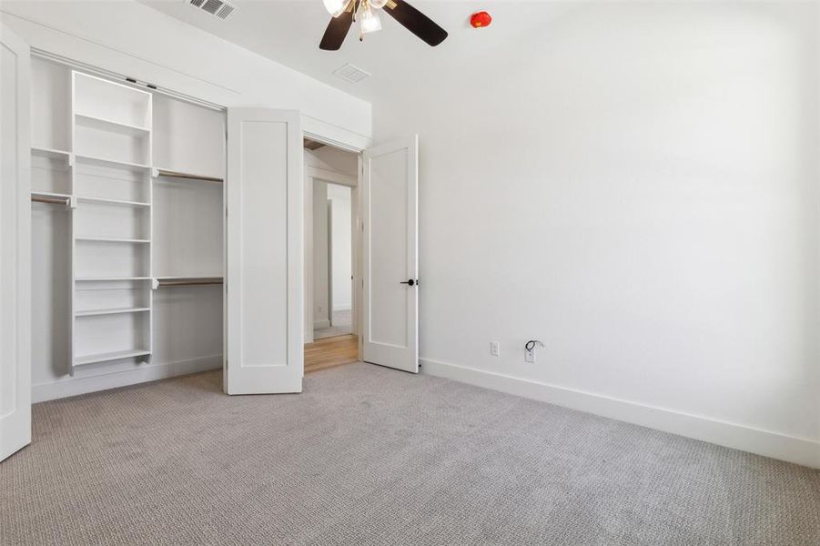 Unfurnished bedroom with light carpet, ceiling fan, and a closet