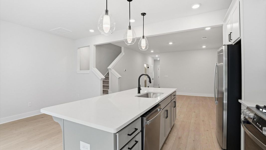 Highly skilled craftsmanship shines in this modern kitchen with pendant lighting and a central island focal point