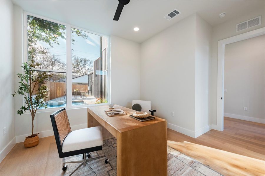 Office area with a wealth of natural light, light wood-type flooring, and visible vents