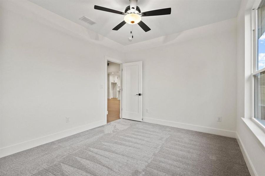 Unfurnished room featuring carpet and ceiling fan