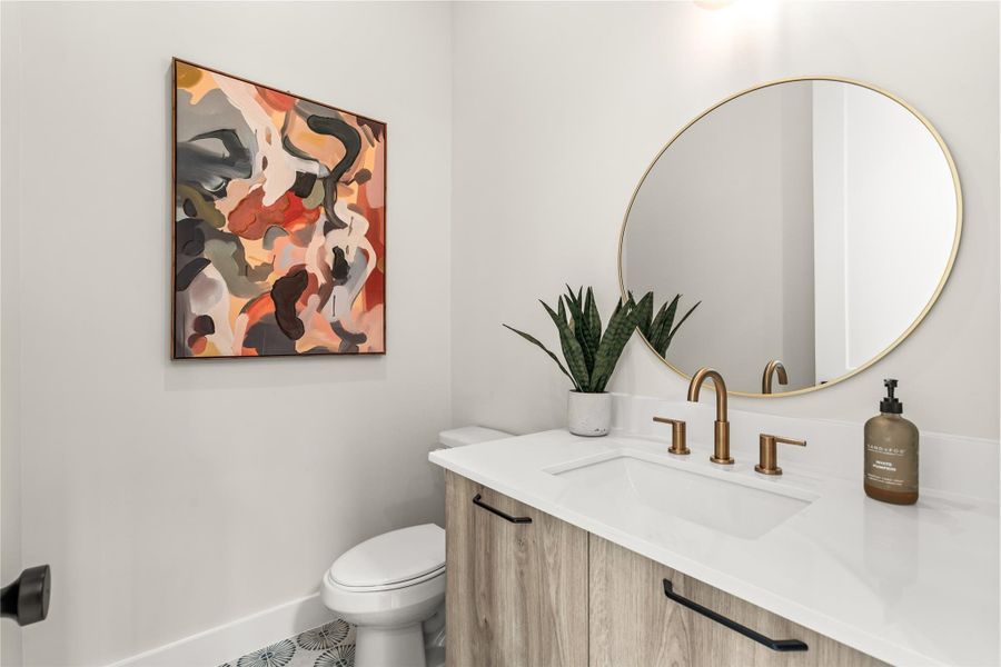 A conveniently placed powder bath serves the main living level, finished with a wide vanity, undermount sink, and quartz countertop.