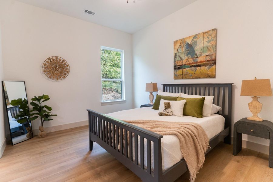Bedroom with light wood finished floors and baseboards Bedroom with light wood finished floors and baseboards