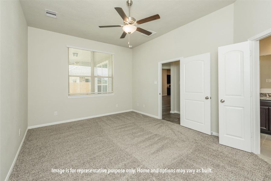 Unfurnished bedroom featuring light colored carpet, ceiling fan, and connected bathroom