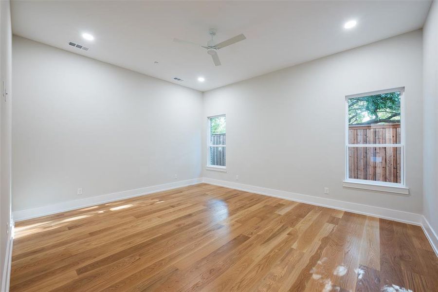 Empty room with ceiling fan and light hardwood / wood-style flooring