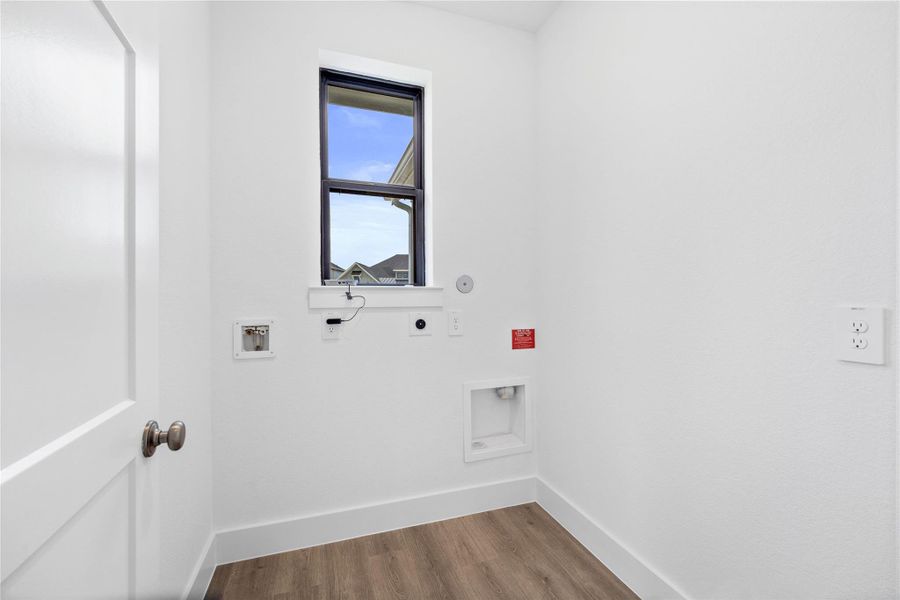 This bright and functional laundry room is conveniently located and ready for your appliances. It features clean white walls and trim, and window providing abundant natural light.