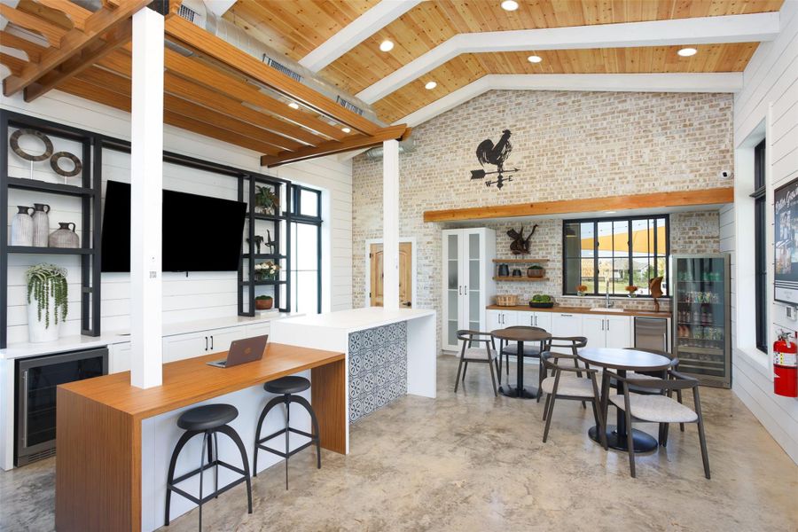 Kitchen with wine cooler, brick wall, high vaulted ceiling, and concrete floors