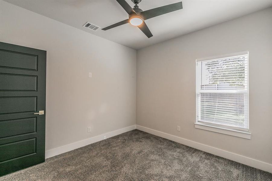 Carpeted spare room featuring ceiling fan