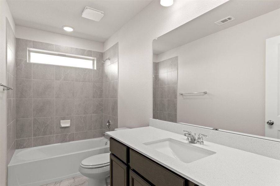 Full bath with vanity, shower / washtub combination, and marble look tile flooring