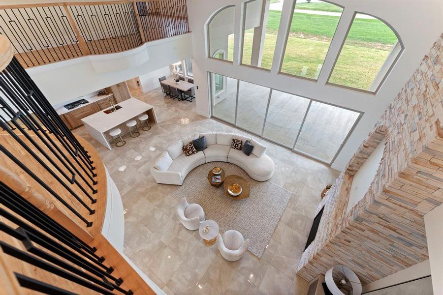 Another view of the gorgeous living room by Star Furniture. There's a glimpse of a sleek kitchen and dining area in the background. The space also overlooks a peaceful outdoor scene.